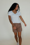 Woman wearing a blue tee and brown shorts