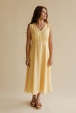 Woman wearing a yellow dress against a beige background
