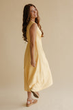 Woman wearing a yellow dress against a beige background