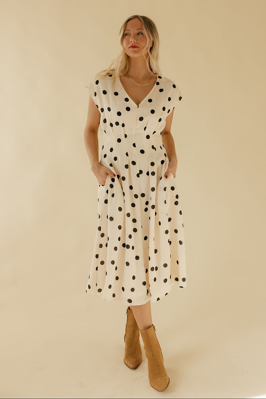 Woman wearing a polka dot dress with a plain background