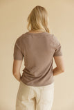 Blonde woman wearing ivory shorts with a brown tee
