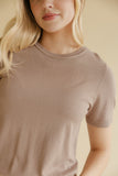 Zoomed in photo of a woman wearing a brown tee