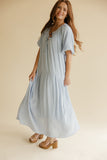 Woman wearing a light blue dress on a beige background