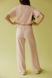 Person wearing a pink and white striped outfit on a yellow background