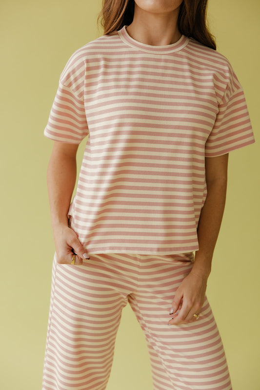Person wearing a pink and white striped outfit on a yellow background