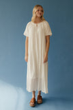 Woman wearing a white dress against a blue background