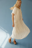 Woman wearing a flowing white dress against a blue background