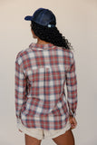 Person wearing a plaid shirt and cap on a plain background