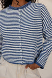 Blue and white striped cardigan worn by a person on a neutral background