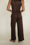 Brown jumpsuit worn by a person on a plain background