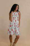 Woman wearing a floral dress against a beige background