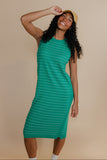 Woman wearing a green striped dress against a beige background