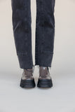 Person wearing black jeans and transparent shoes on a white background