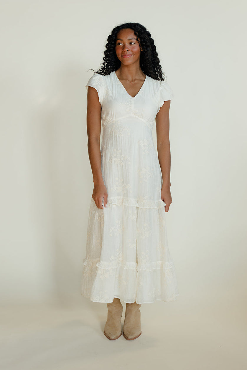 Woman wearing a white dress against a plain background