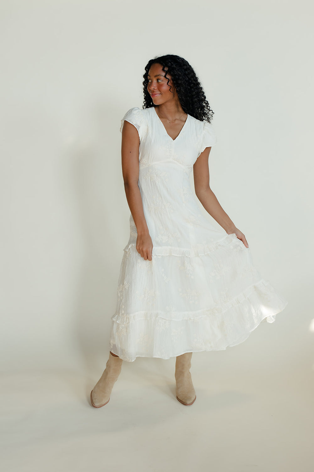 Woman wearing a white dress against a plain background