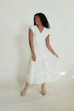 Woman wearing a white dress against a plain background