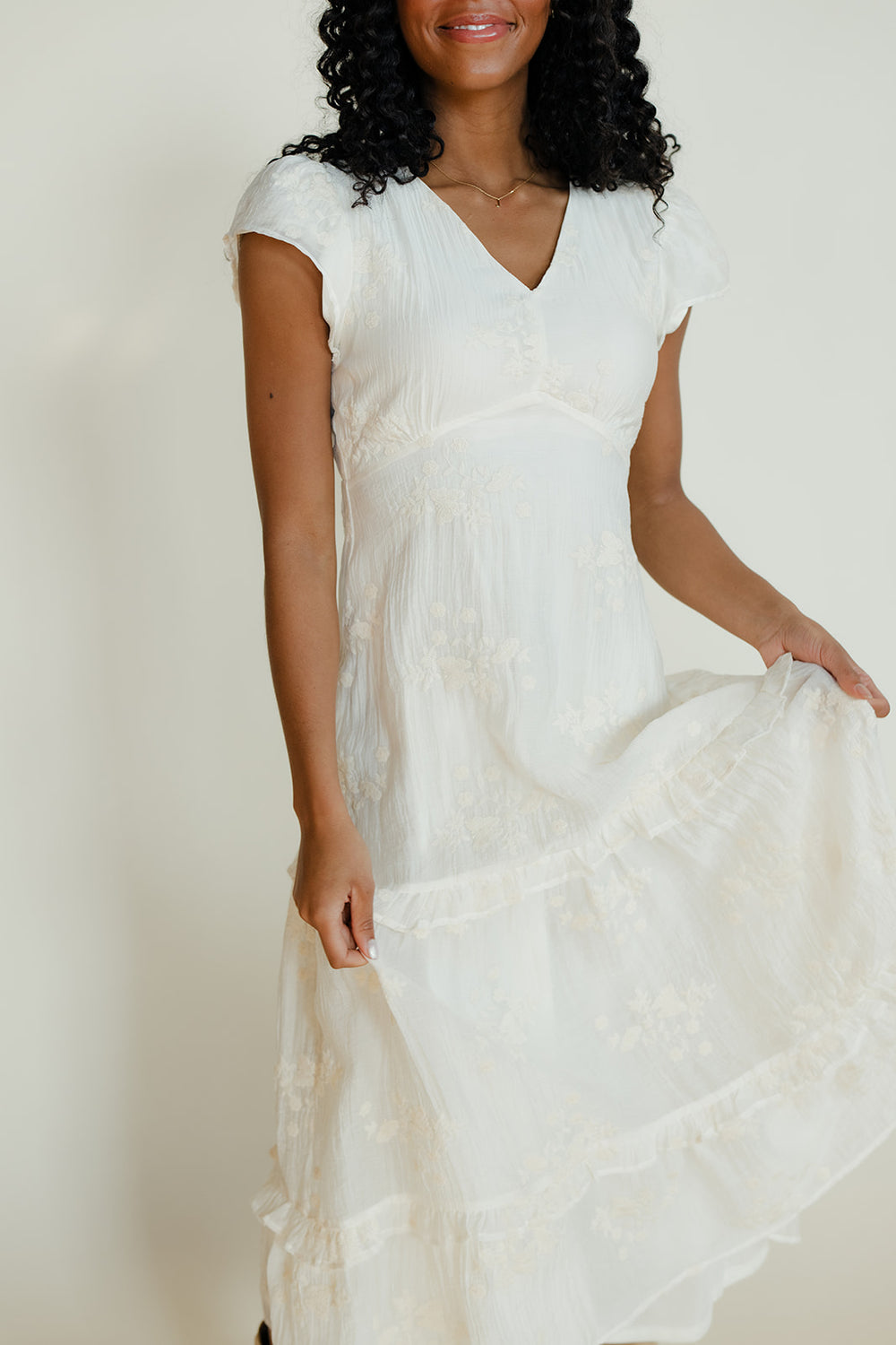 Woman wearing a white dress against a plain background