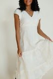 Woman wearing a white dress against a plain background