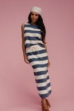 Woman wearing a blue and white striped dress on a pink background