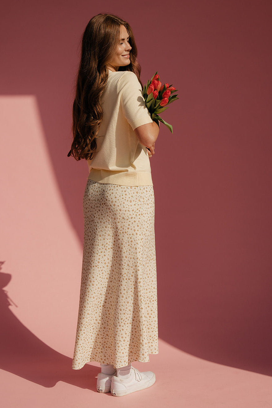 Woman holding flowers against a pink background