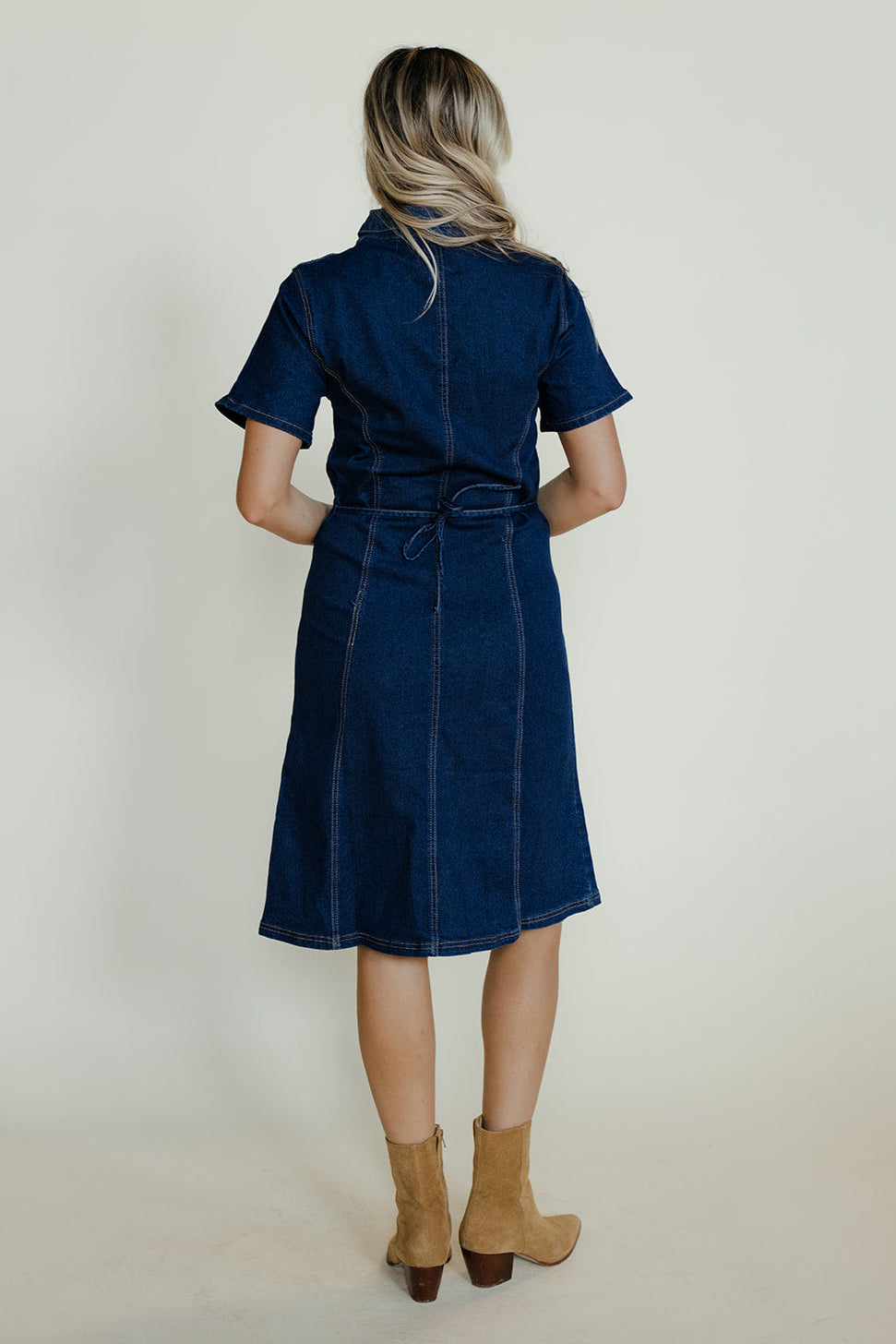 Woman wearing a blue dress with a plain background