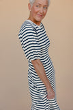 Woman wearing a striped dress against a beige background