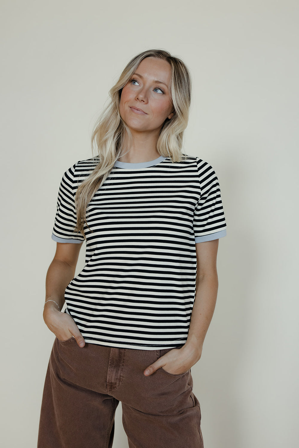 Woman wearing a black and white striped shirt against a plain background