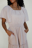 Woman wearing a checkered dress with a plain background