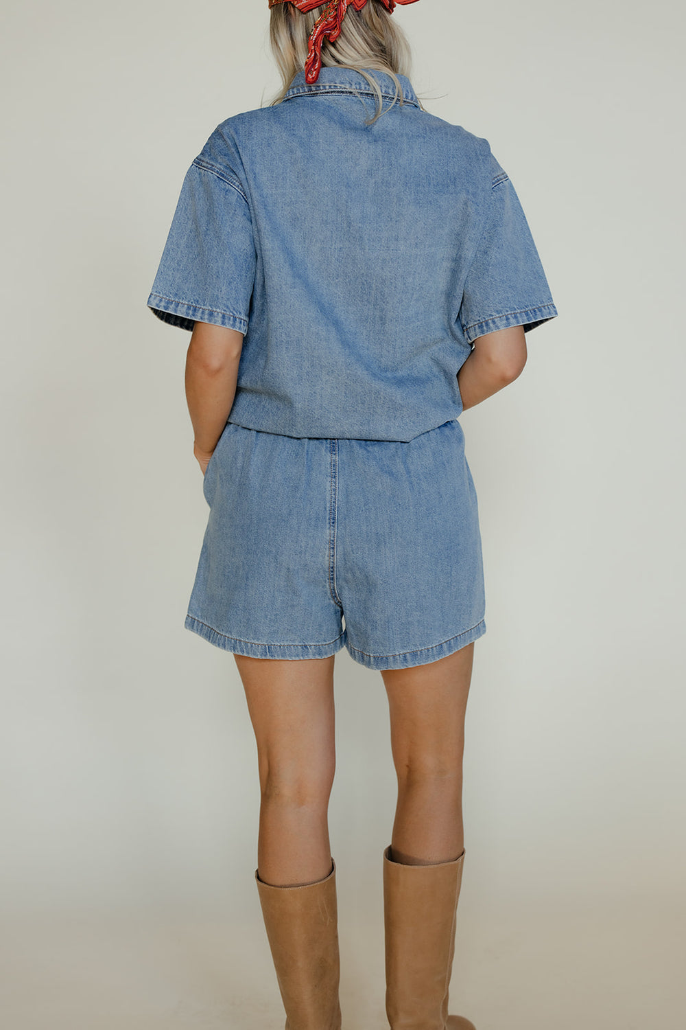 Person wearing a denim outfit with a plain background