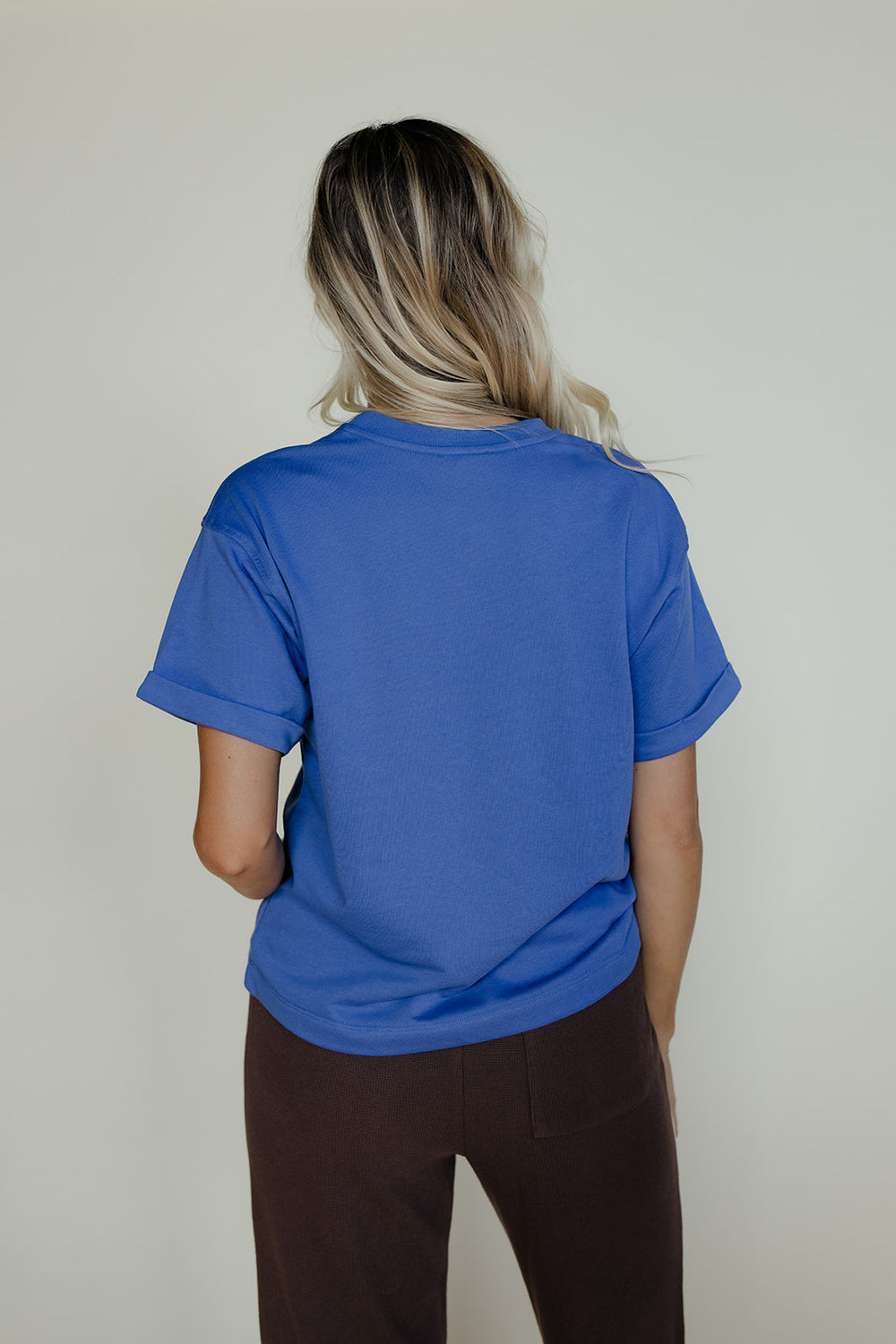 Person wearing a blue t-shirt against a plain background