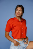 Woman wearing a red sleeveless shirt against a blue background