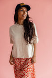 Women wearing a button up cardigan and cherry print skirt