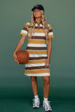 Woman in a striped dress holding a basketball against a green background
