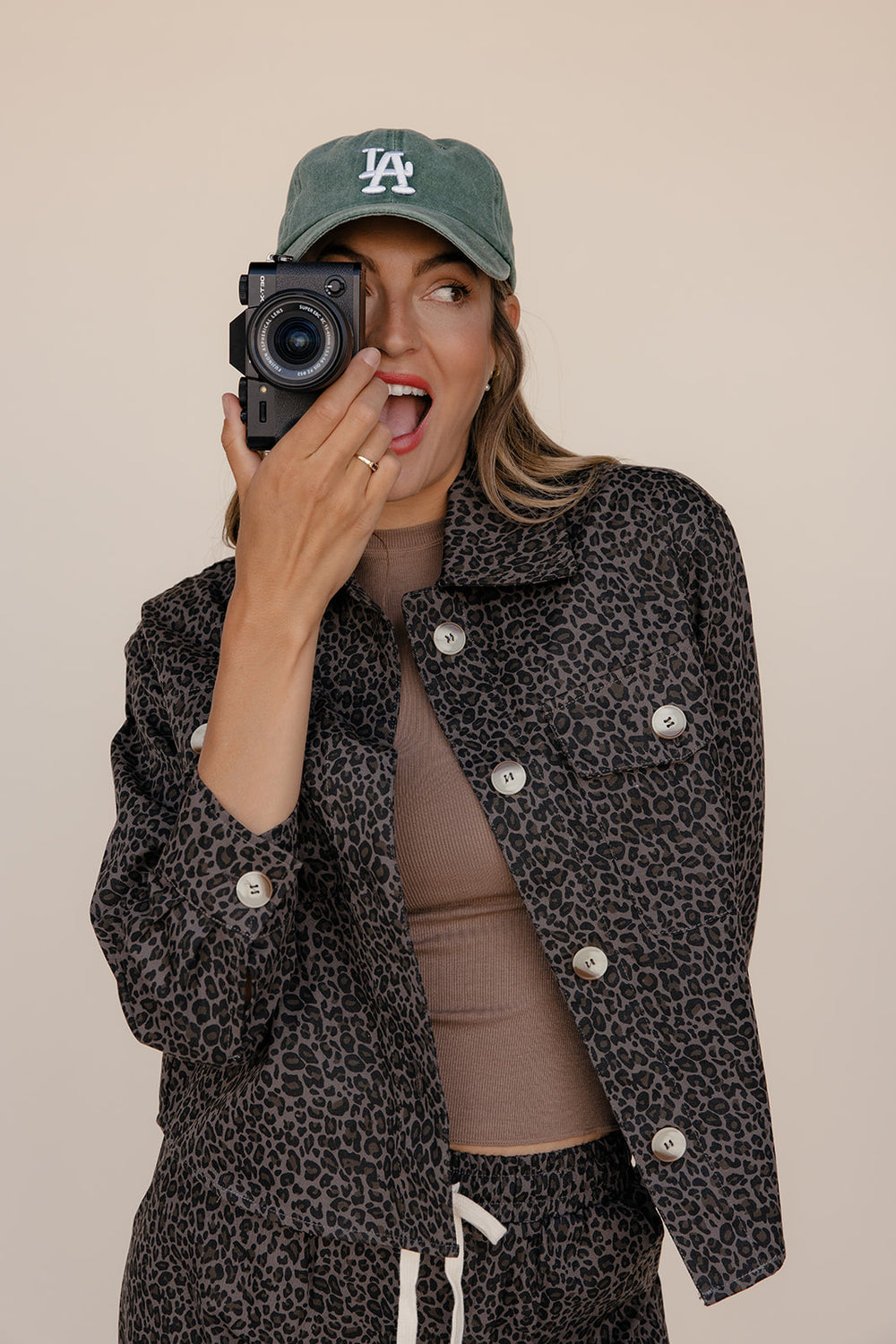 Person holding a camera with a neutral background