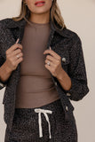 Person wearing a brown top and leopard print jacket and pants.