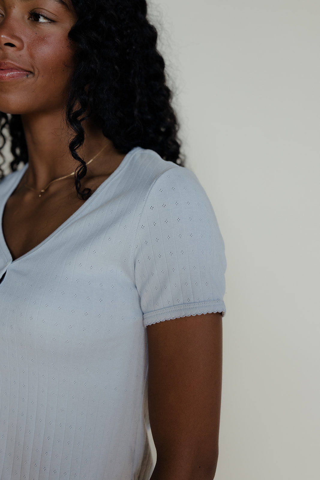 Woman wearing a blue pointelle tee