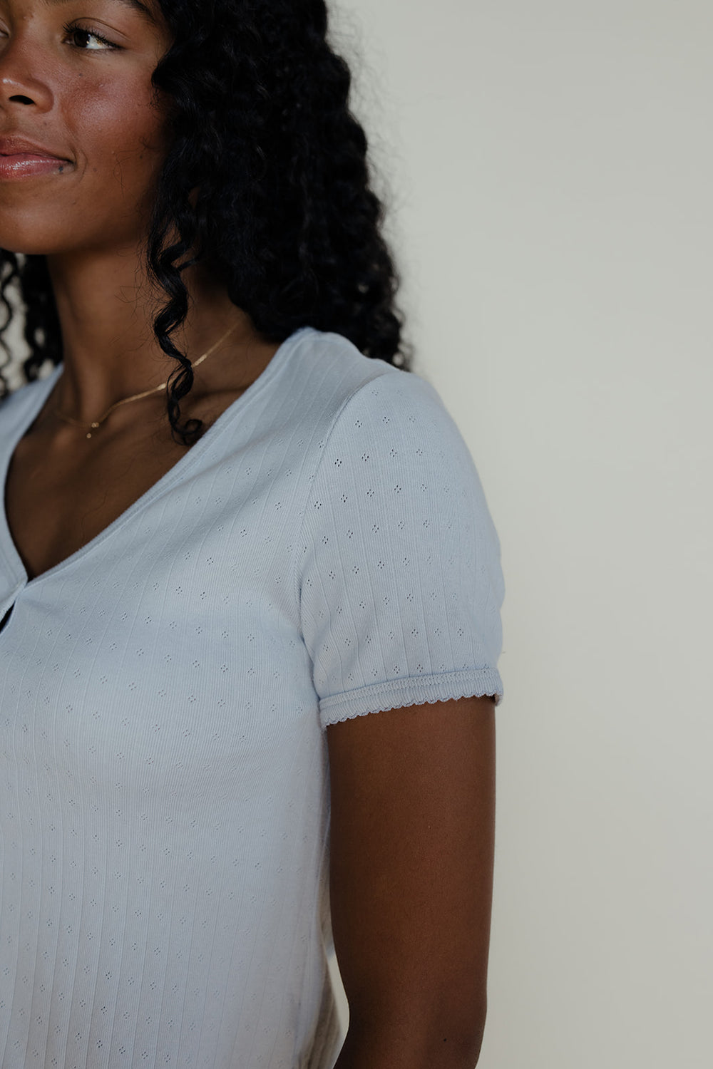 Woman wearing a blue pointelle tee