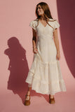 Woman wearing a white dress against a pink background
