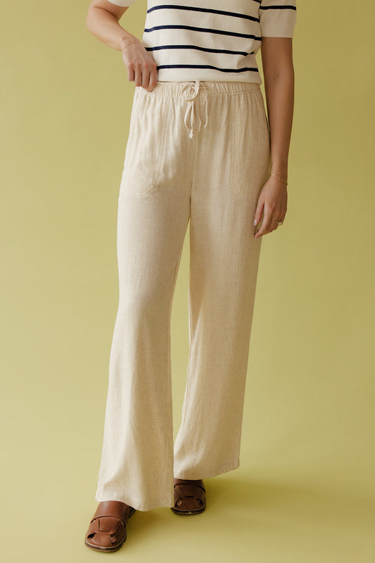 Person wearing a striped shirt and wide-leg pants on a yellow background