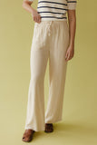 Person wearing a striped shirt and wide-leg pants on a yellow background