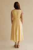 Woman wearing a yellow dress against a beige background