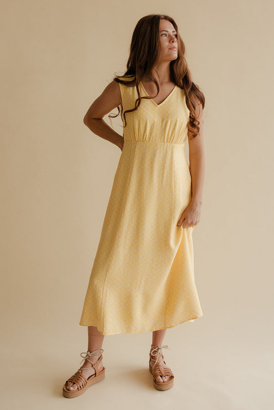 Woman wearing a yellow dress against a beige background