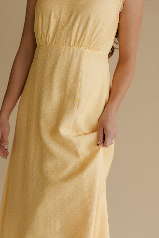 Yellow dress worn by a person on a beige background