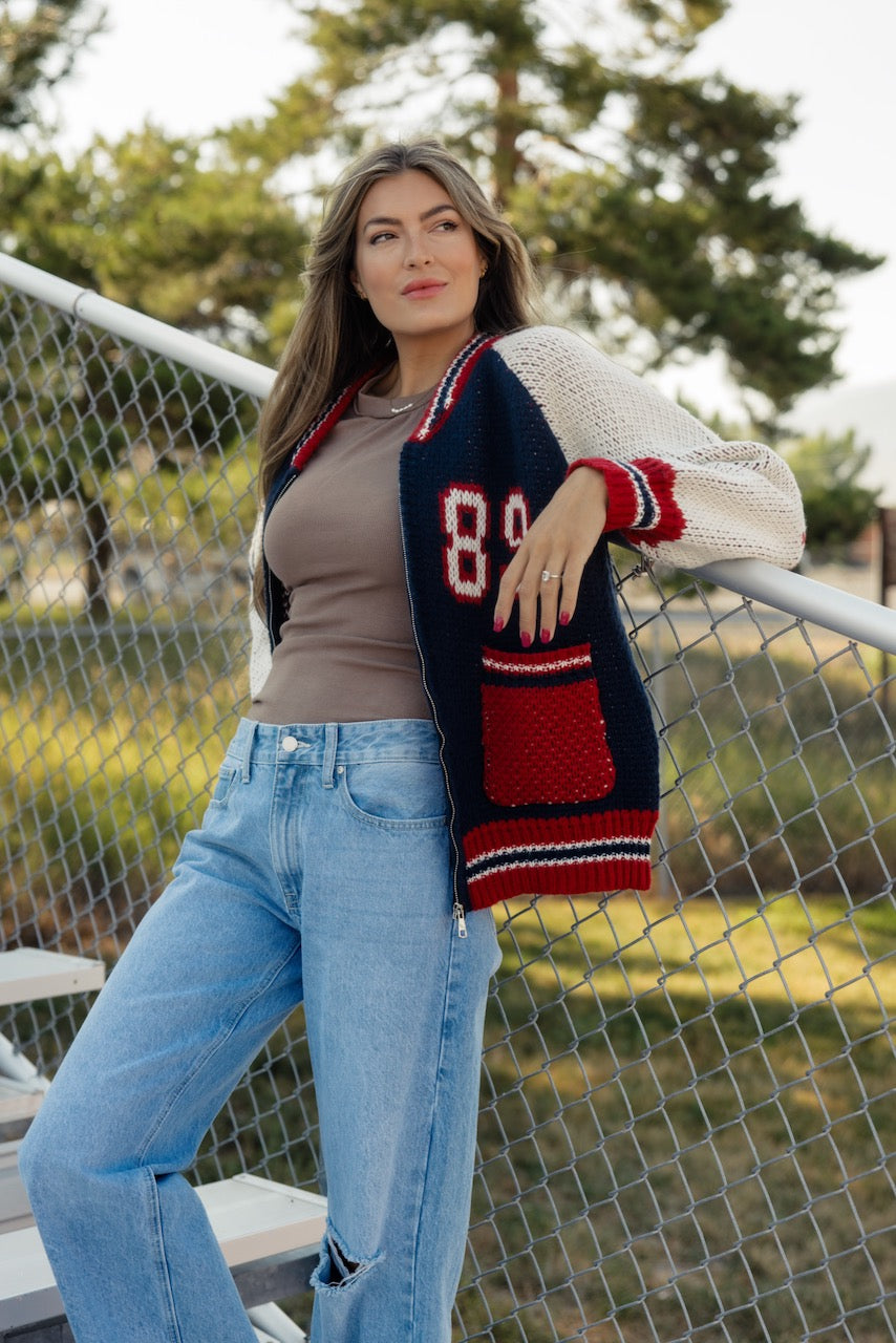 a woman leaning against a fence