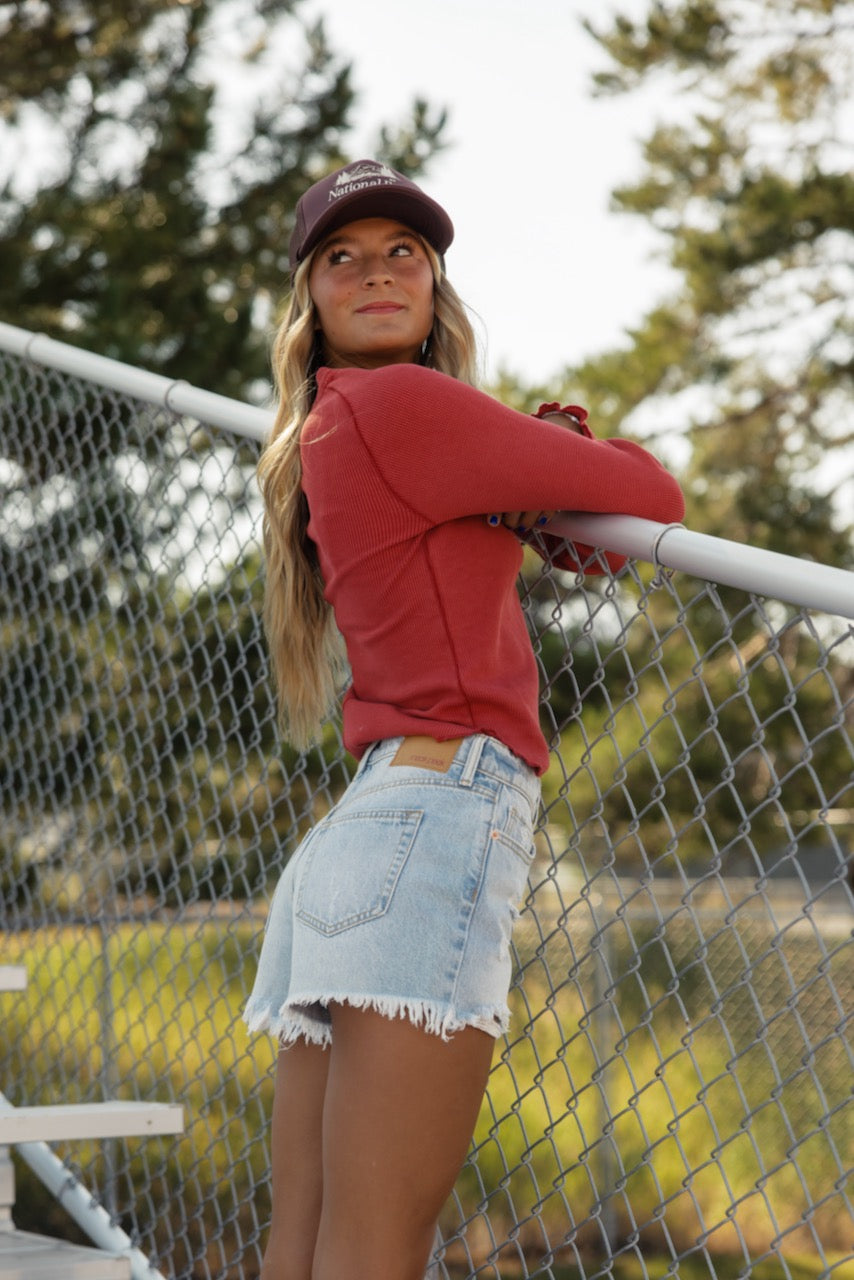 a woman leaning on a fence