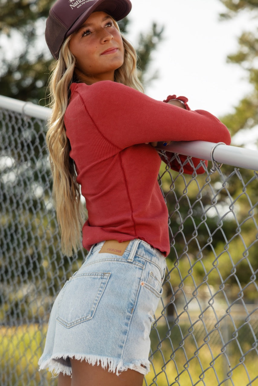 a woman leaning on a fence