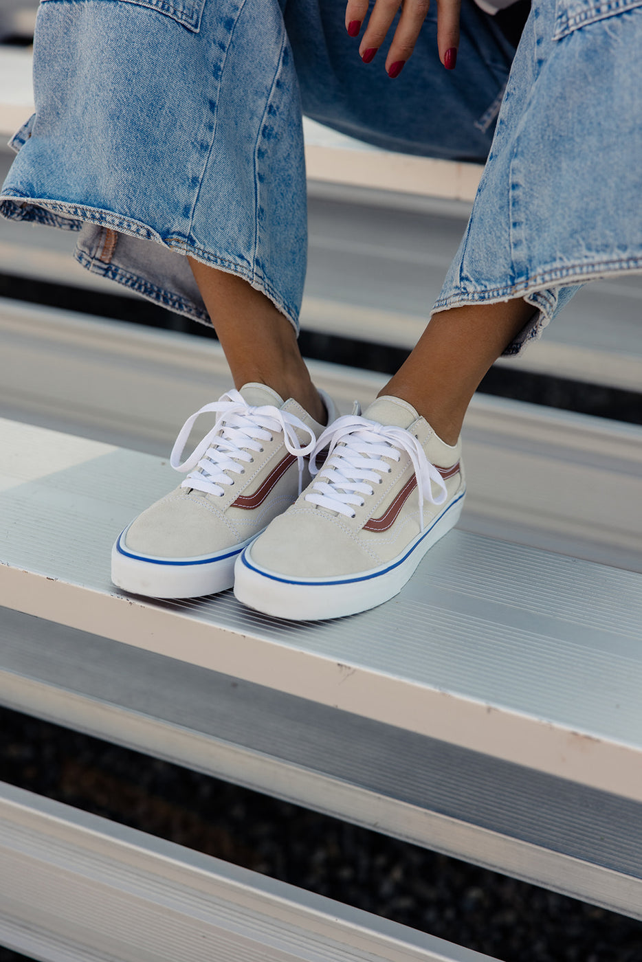 a person's feet wearing white sneakers and jeans