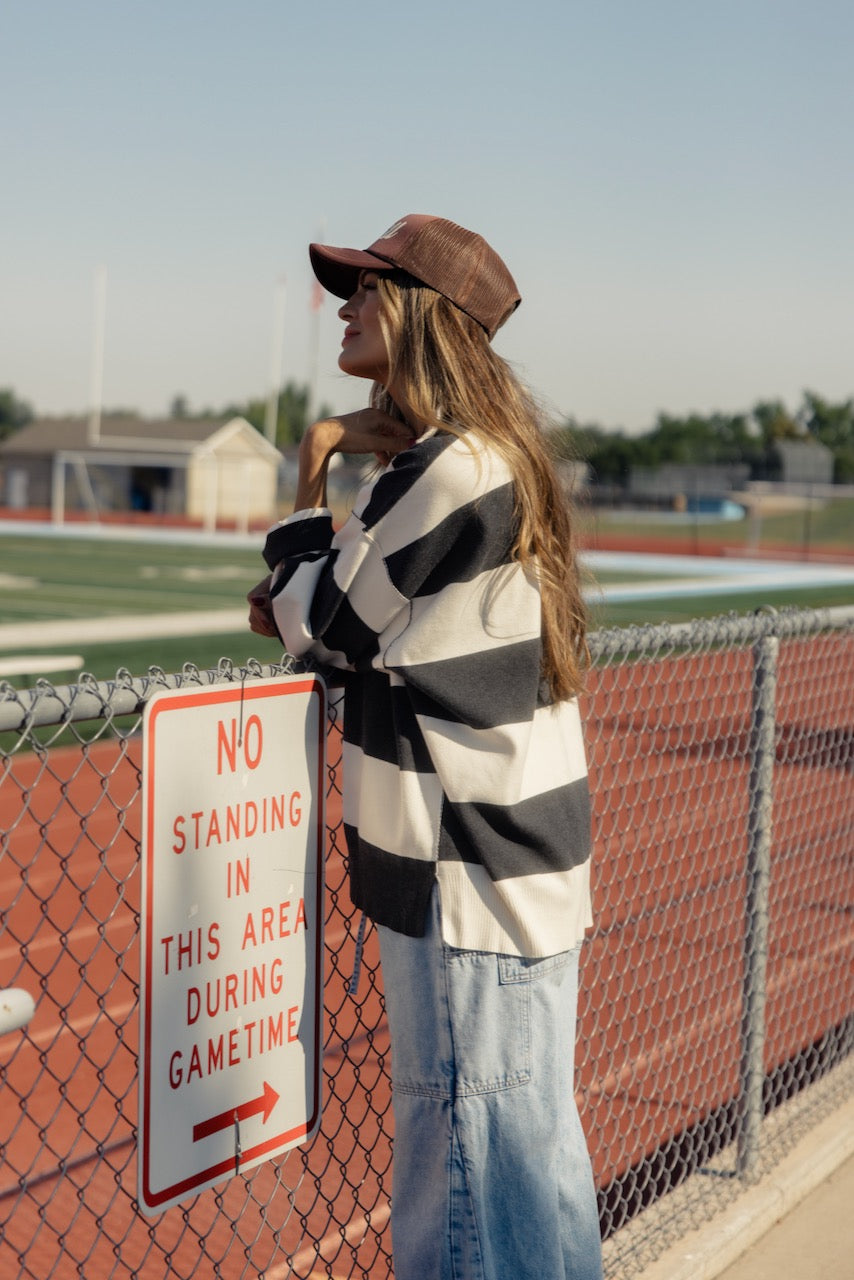 a woman leaning against a fence