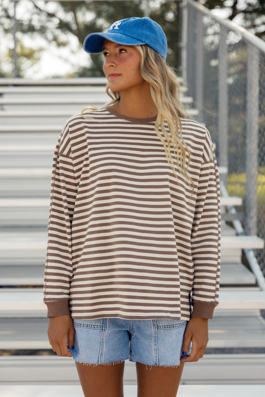 a woman standing in front of a bleachers