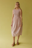 Woman wearing a pink checkered dress against a yellow background